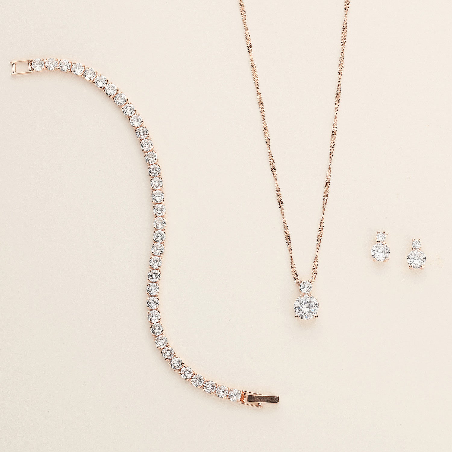 a necklace, earrings, and bracelet on a white surface