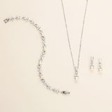 a necklace, earrings, and bracelet on a white surface