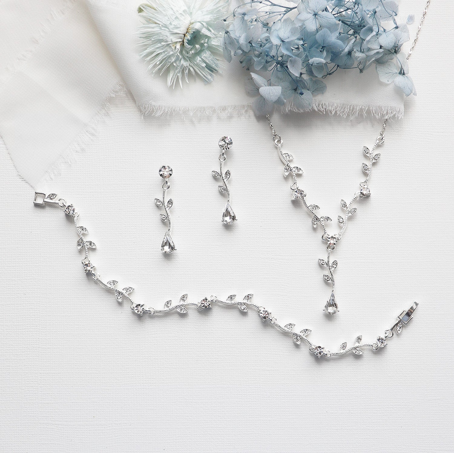 a necklace and earrings on a white cloth