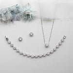 a necklace, earrings, and bracelet on a white surface