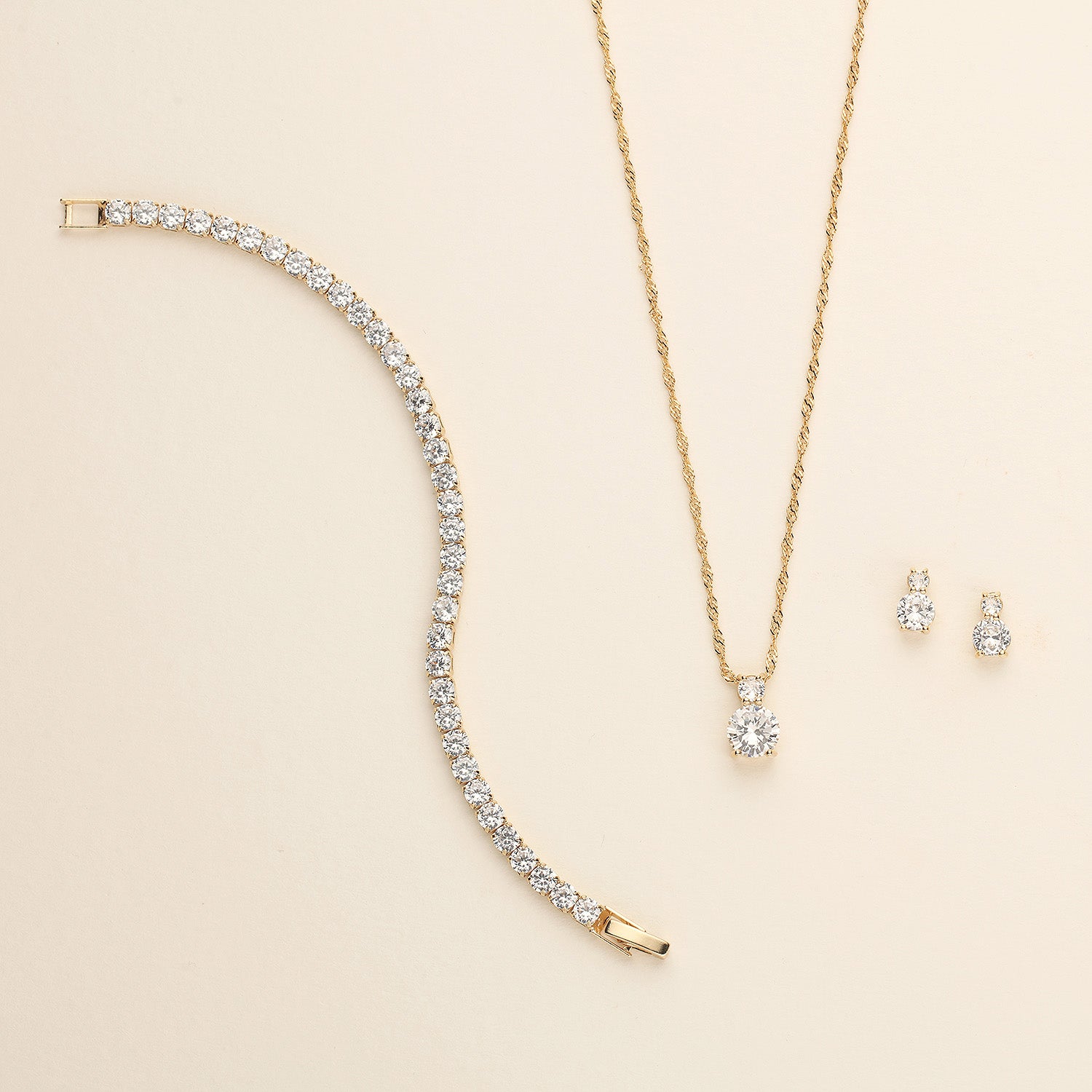 a diamond necklace and earring set on a white surface