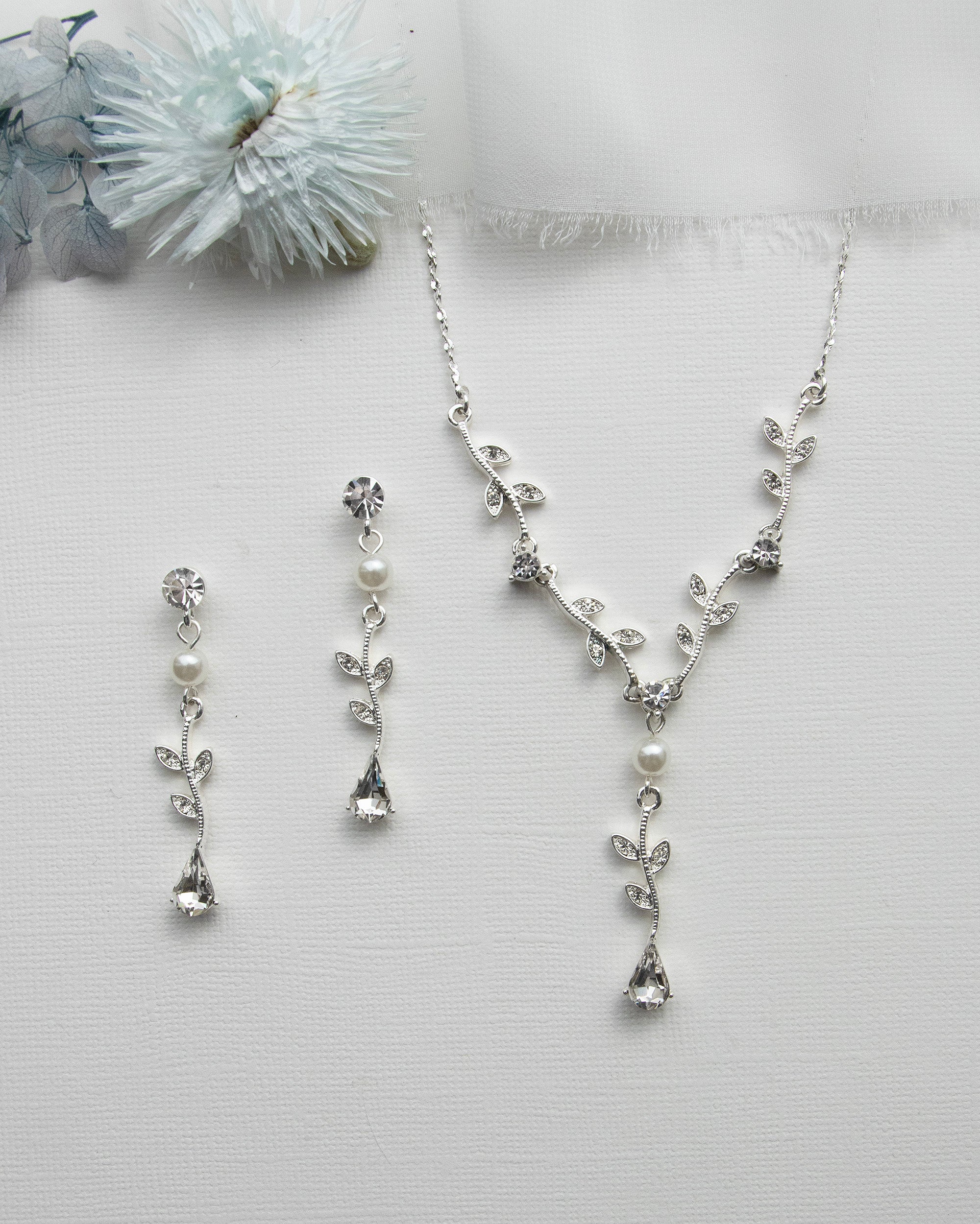 a necklace and earring set with a flower