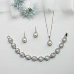 a necklace and earring set with a flower in the background