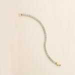 a gold and diamond bracelet on a white background