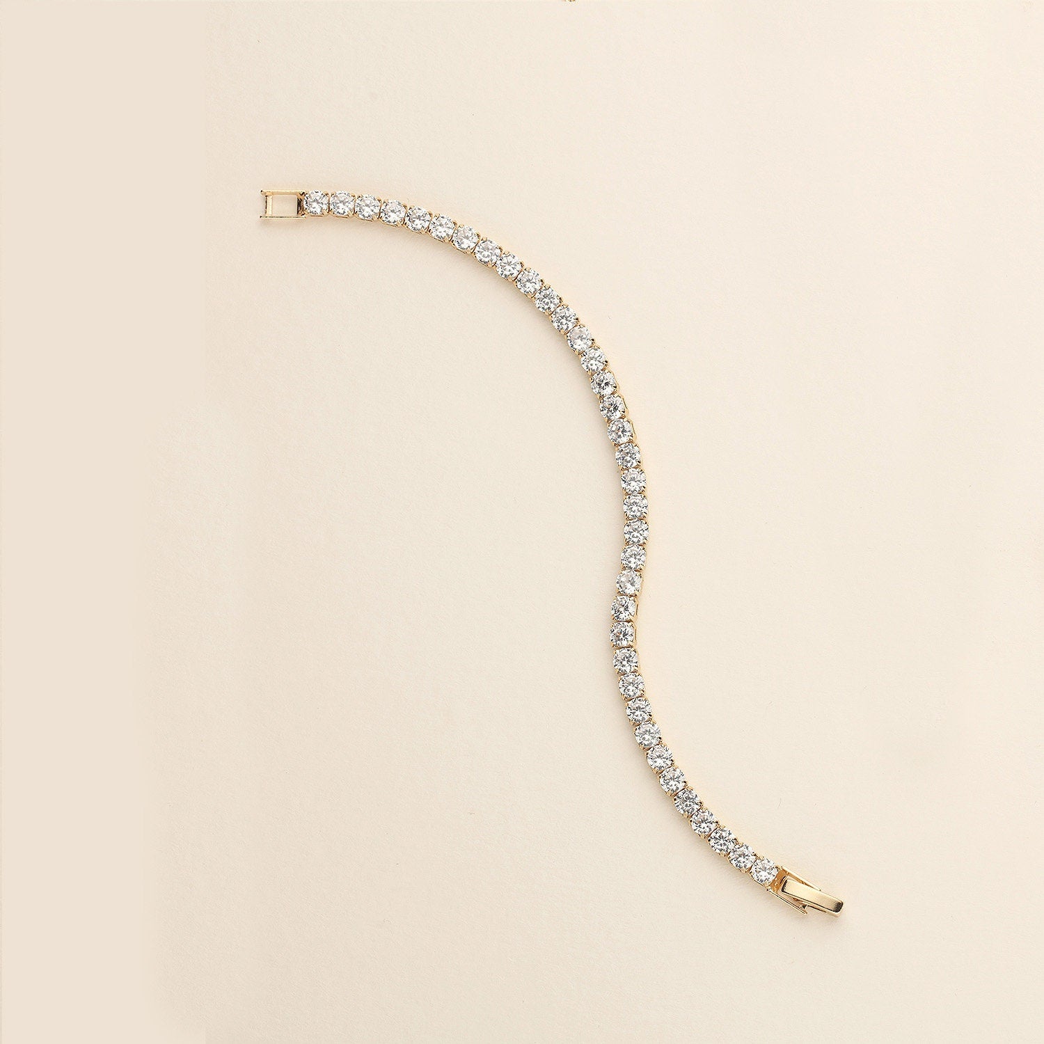 a gold and diamond bracelet on a white background