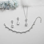 a necklace, earrings, and bracelet on a white surface