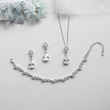 a necklace, earrings, and bracelet on a white surface