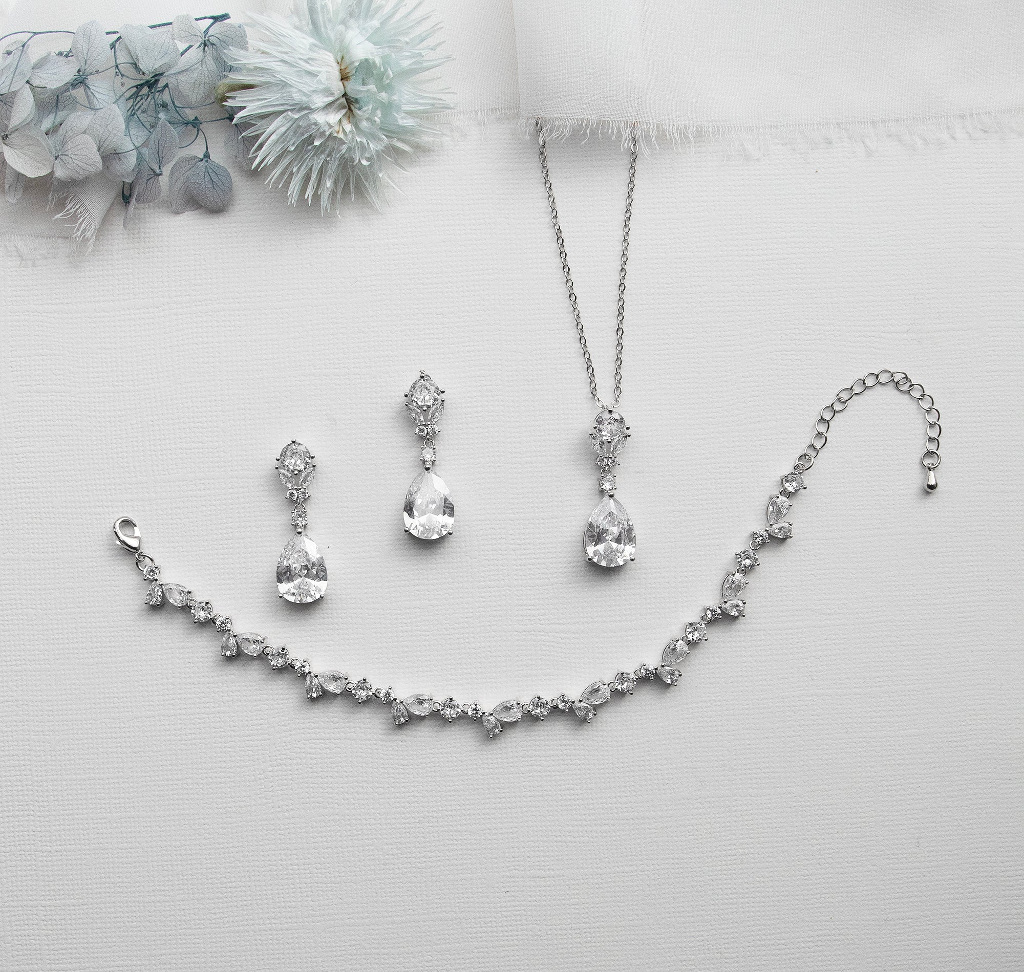 a necklace, earrings, and bracelet on a white surface