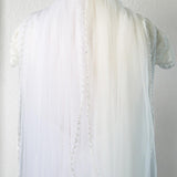 the back of a white shirt with pearls on it