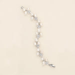 a white pearl and crystal bracelet on a white background