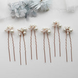 a row of hair pins with pearls on them