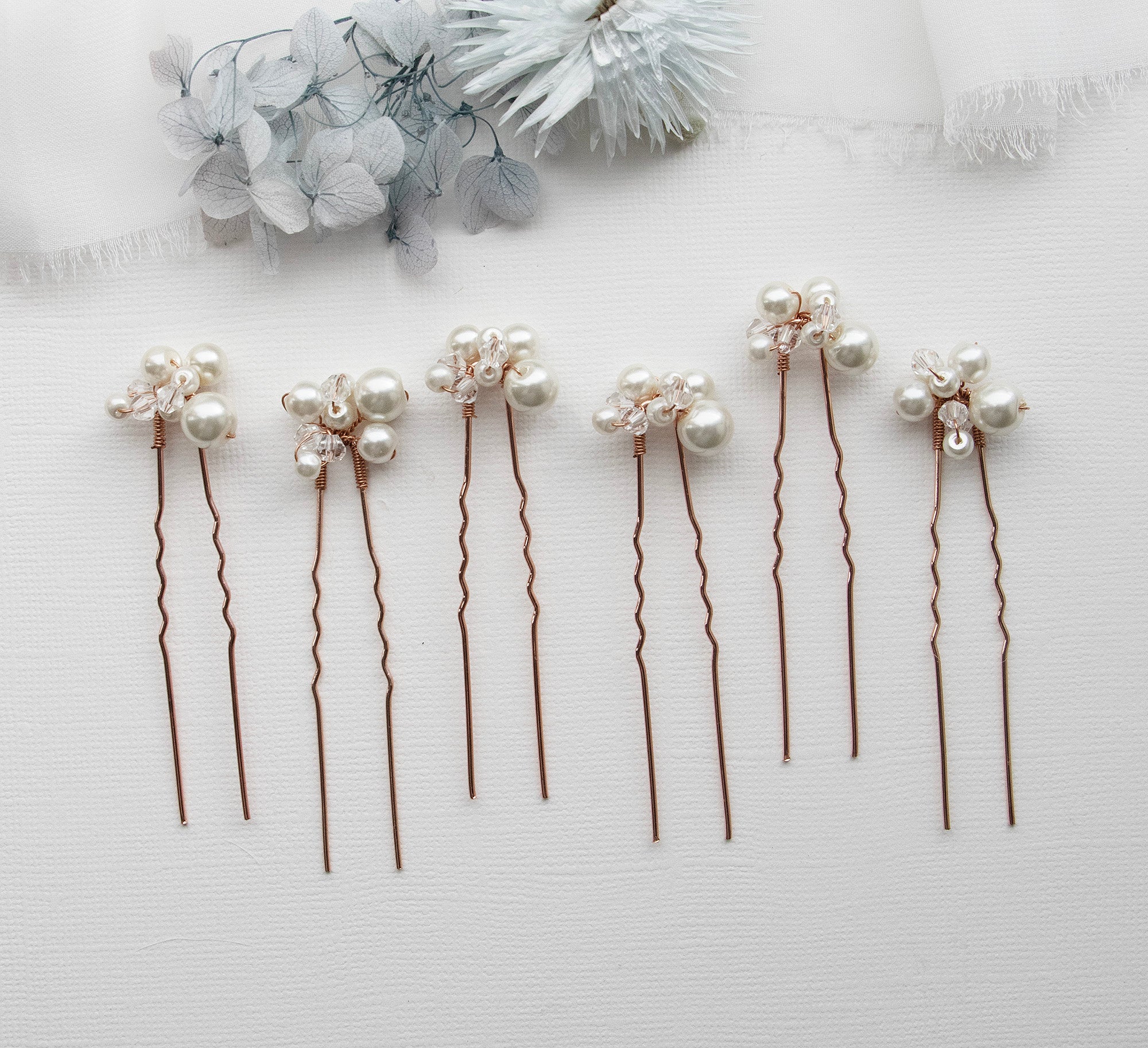 a row of hair pins with pearls on them