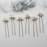a row of hair pins with pearls on them
