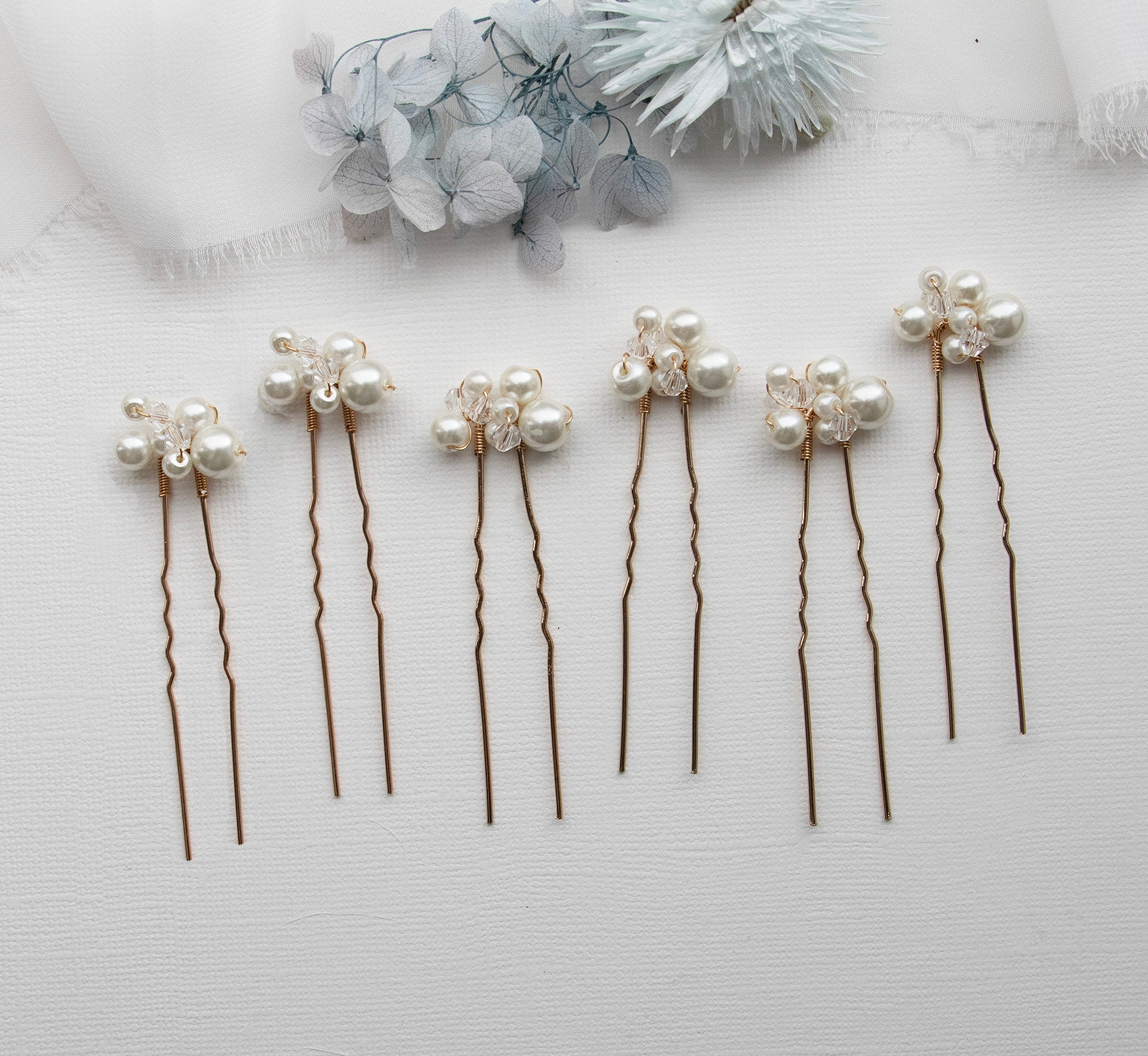 a row of hair pins with pearls on them