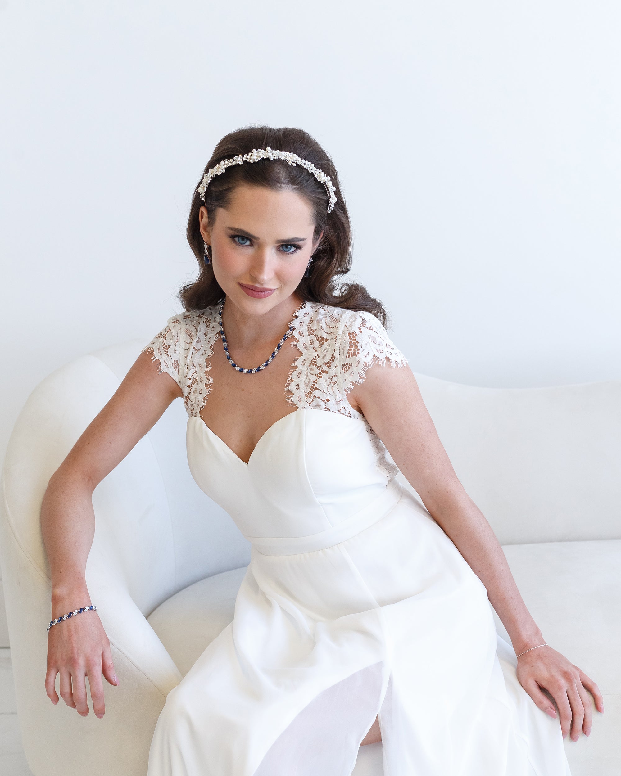 a woman in a white dress sitting on a white couch