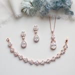 a necklace, earrings, and bracelet on a white surface