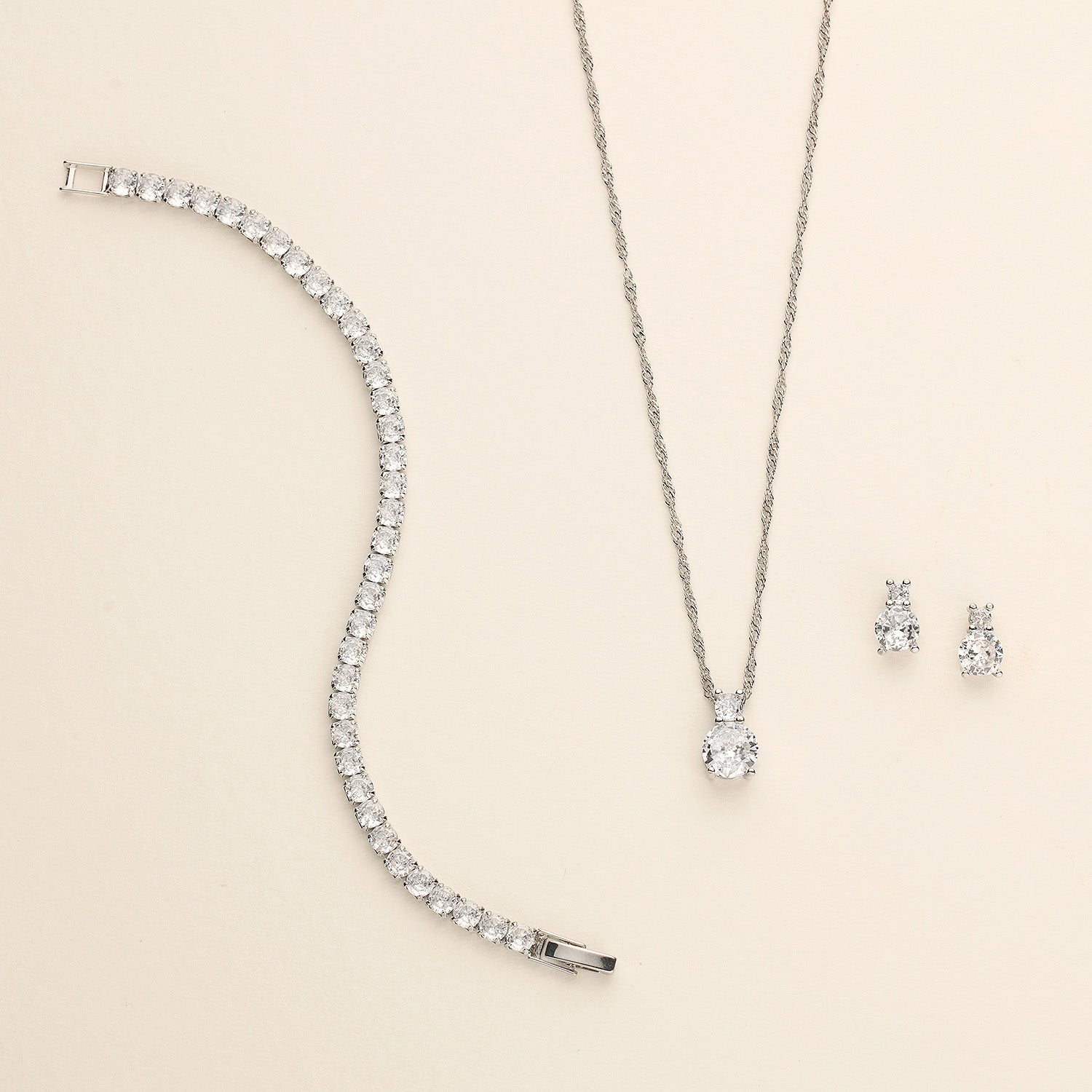 a necklace, earrings, and bracelet on a white surface