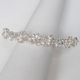 A decorative piece of jewelry, possibly a tiara or headband, is displayed on a white cloth.