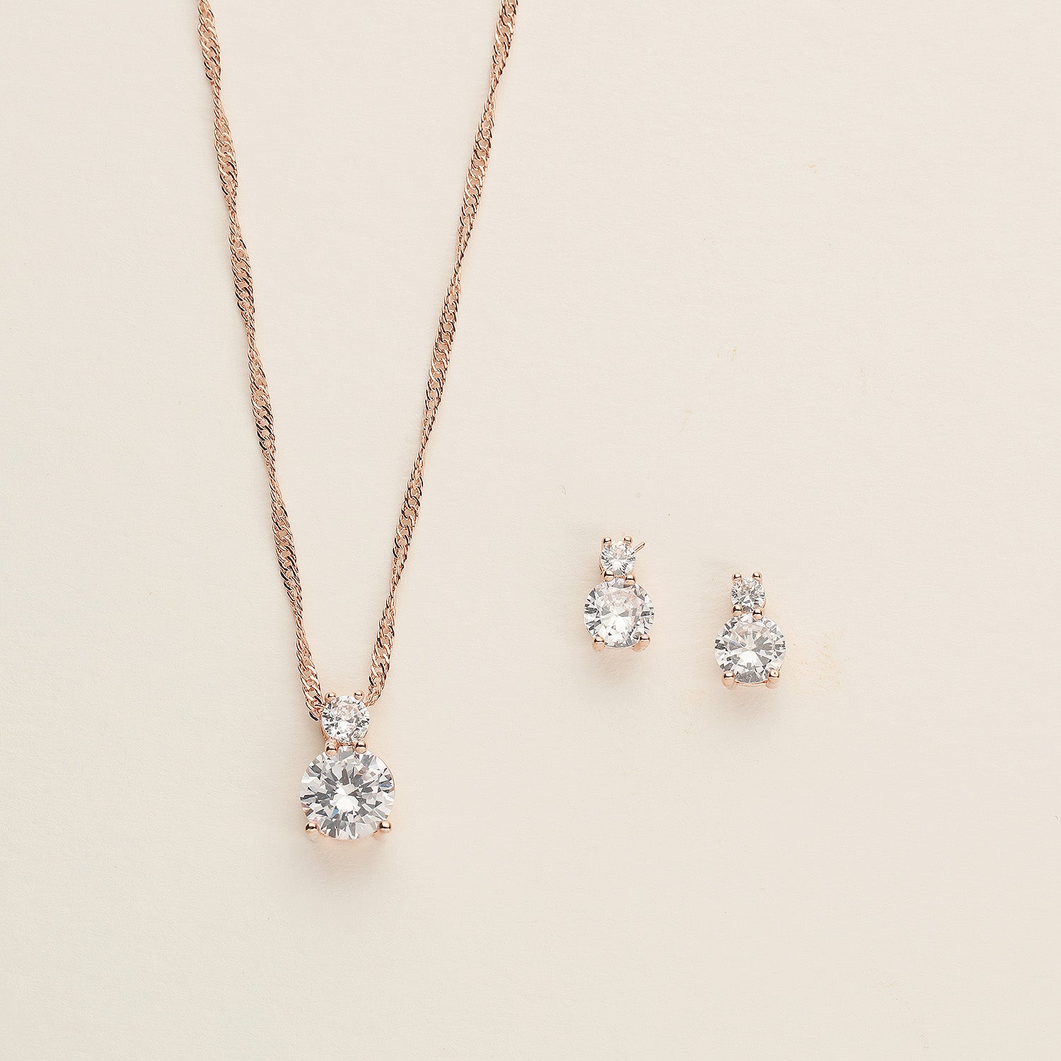 a necklace and earring set on a white surface