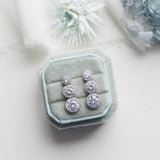 a pair of earrings sitting on top of a white table