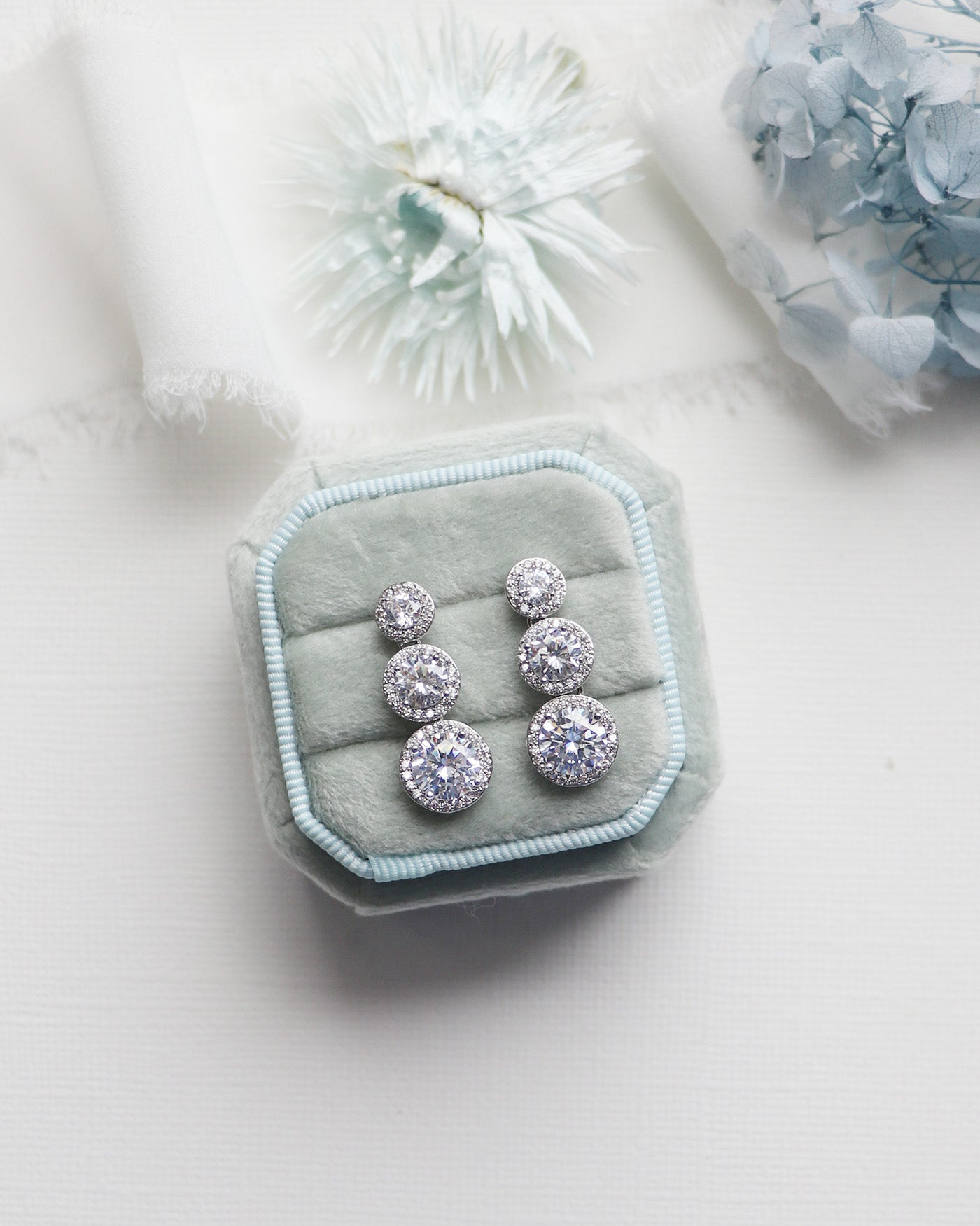 a pair of earrings sitting on top of a white table