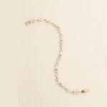 a pearl and gold necklace with a watch on it