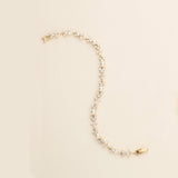 a pearl and gold necklace with a watch on it