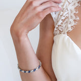 a woman wearing a white dress and a blue beaded bracelet