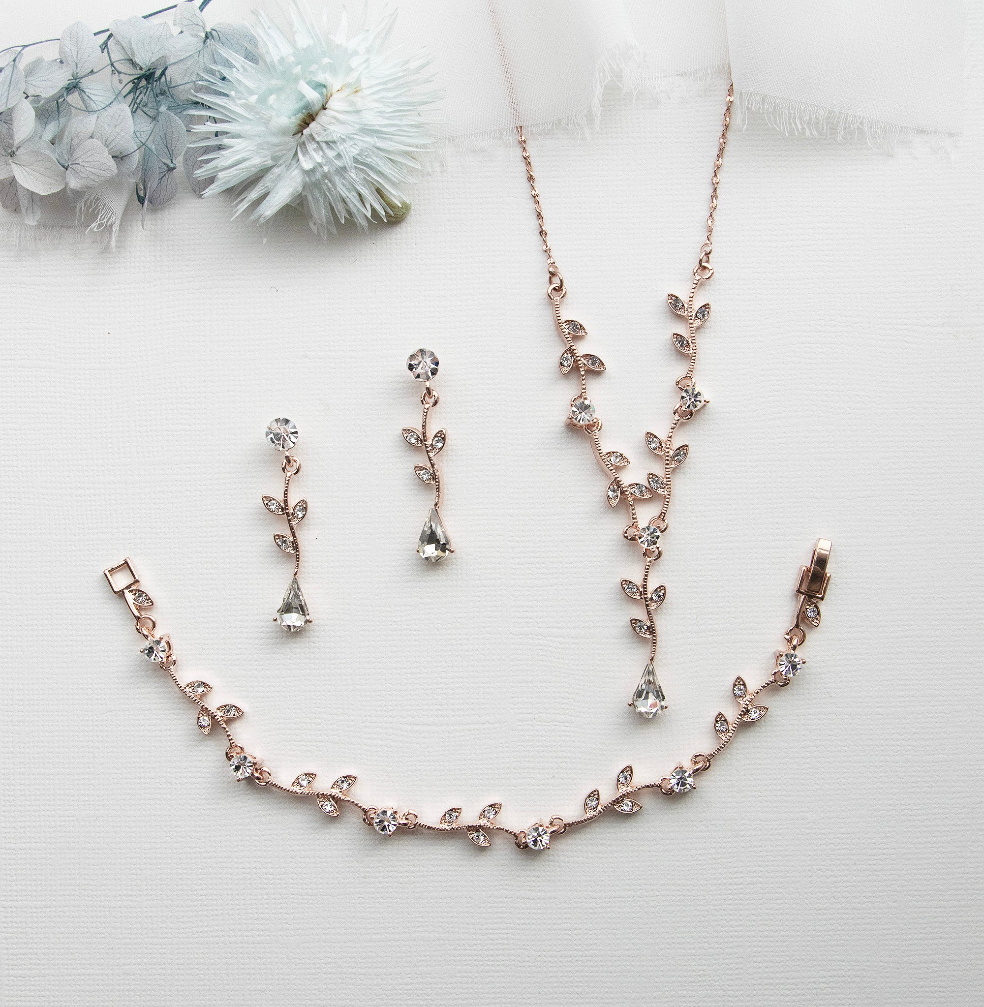 a necklace and earring set on a white surface