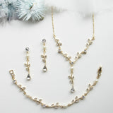 a necklace, bracelet, and earring set on a white surface