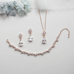 a necklace, earrings, and bracelet on a white surface