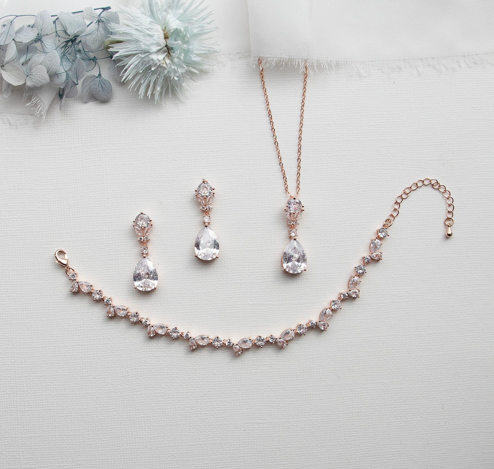 a necklace, earrings, and bracelet on a white surface