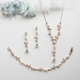 a necklace, bracelet, and earring set on a white surface