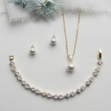 a necklace, earrings, and bracelet on a white surface