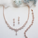 a necklace and earrings on a white surface