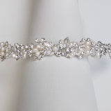 A close-up view of a decorative bracelet or necklace with a combination of pearls, crystals, and pearls.