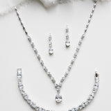 a necklace and earring set on a white surface