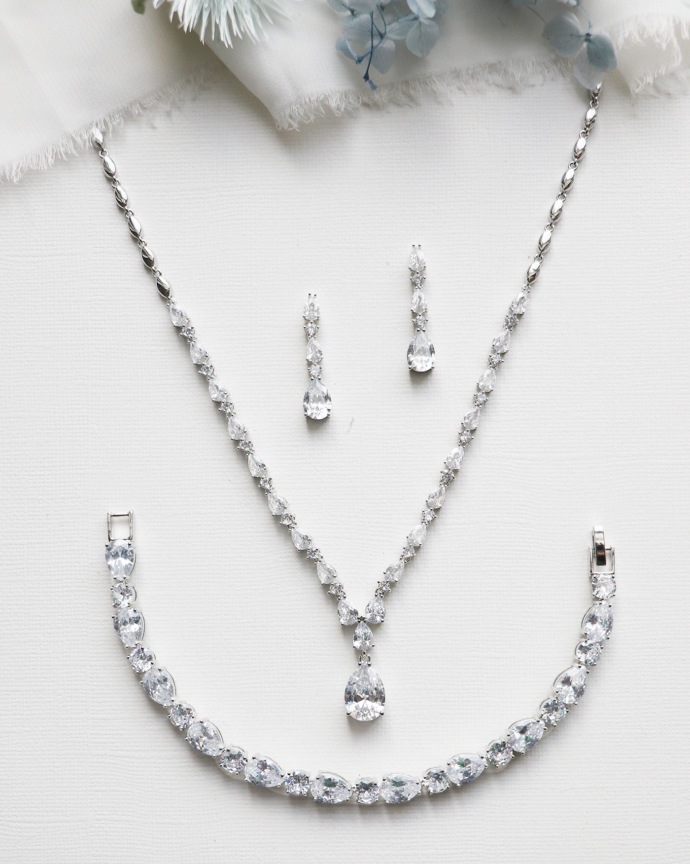 a necklace and earring set on a white surface