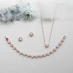 a necklace, earrings, and bracelet on a white surface