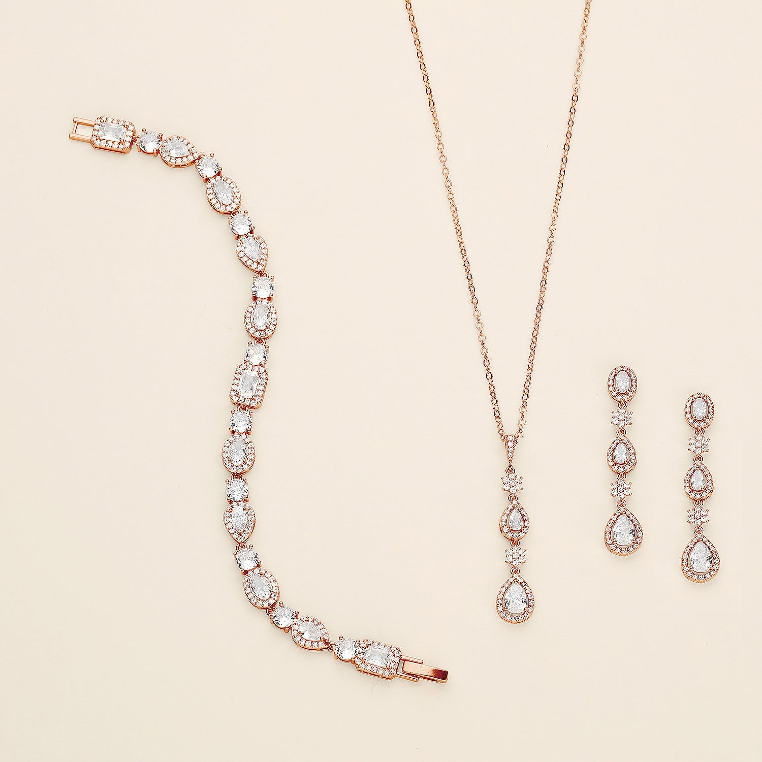 a necklace, bracelet, and earrings on a white surface