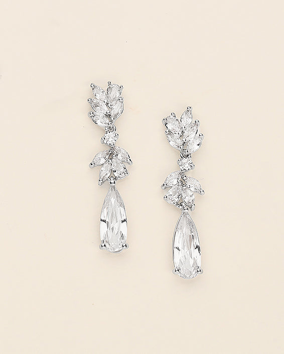 a pair of diamond earrings on a white background