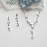 a necklace, earrings, and a bouquet of flowers on a table