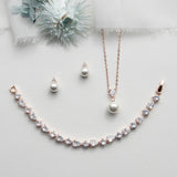 a necklace, earrings, and a flower on a white surface