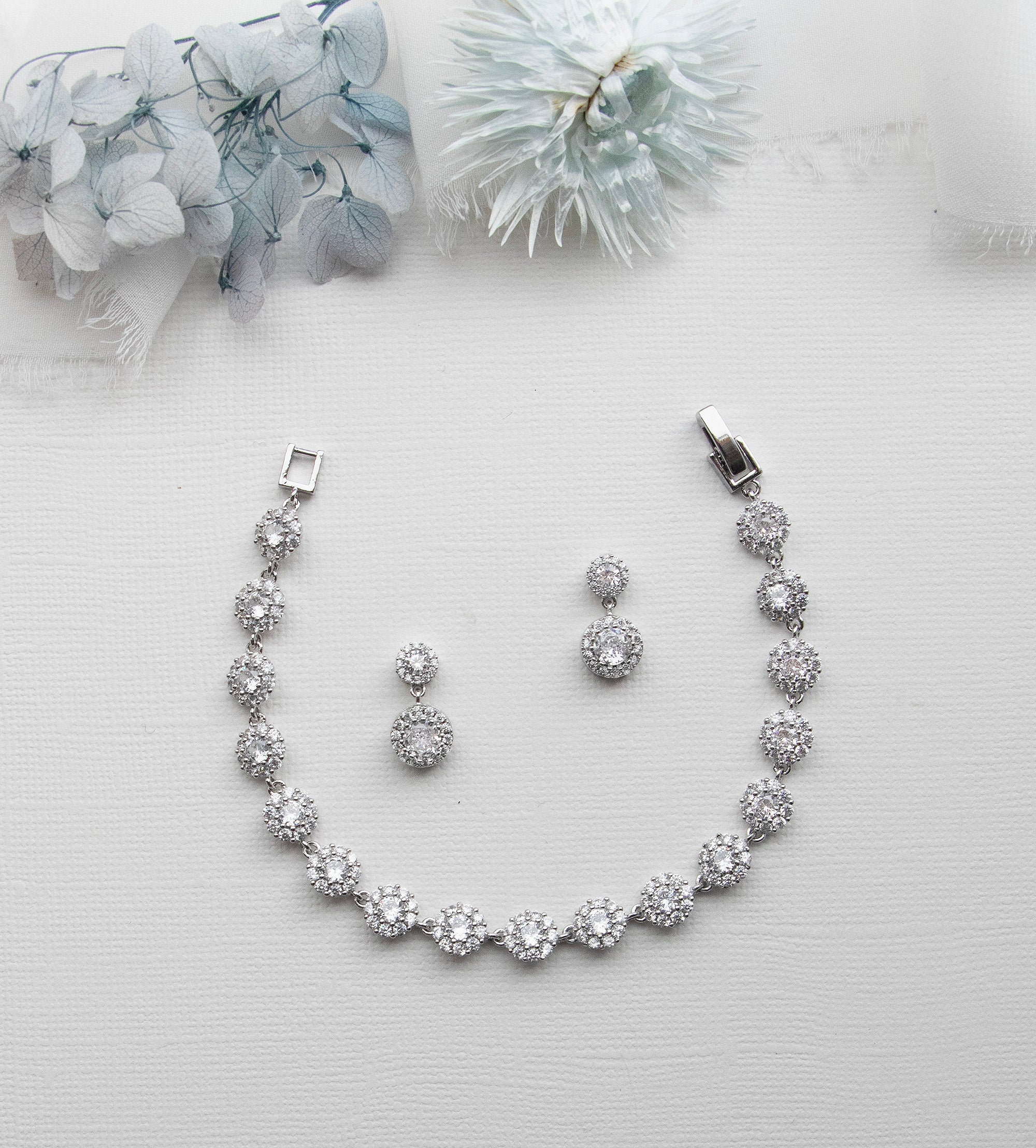 a necklace and earring set on a white surface