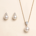 A necklace with a pendant and earrings made of pearls and diamonds.