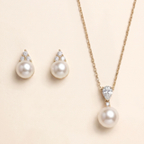 A necklace with a pendant and earrings made of pearls and diamonds.