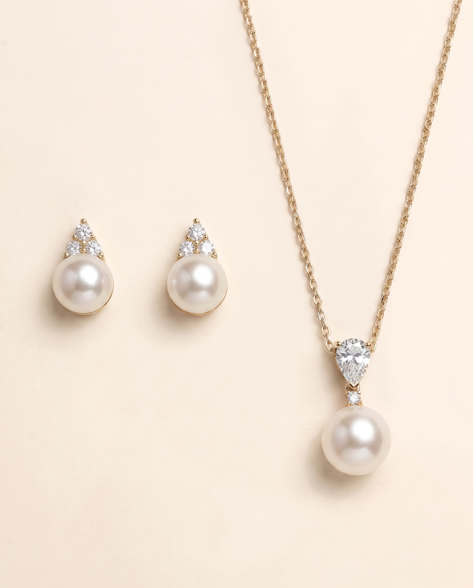 A necklace with a pendant and earrings made of pearls and diamonds.