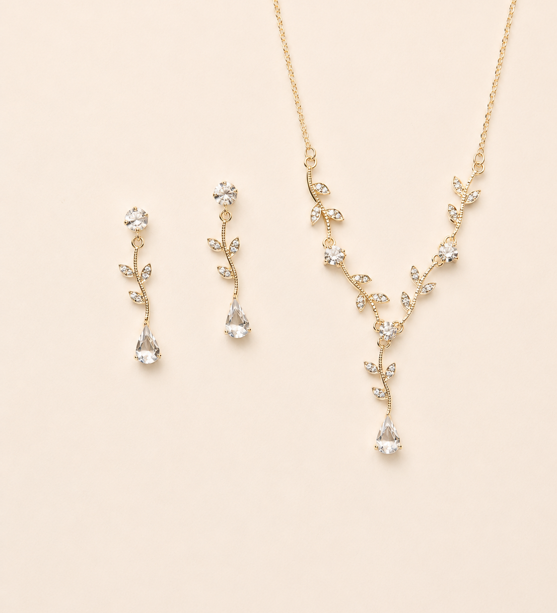 A delicate gold necklace and earrings set with small, clear gemstones.