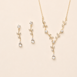 A delicate gold necklace and earrings set with small, clear gemstones.