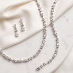 a collection of elegant jewelry pieces, including a necklace, earrings, and a bracelet, all adorned with sparkling diamonds.